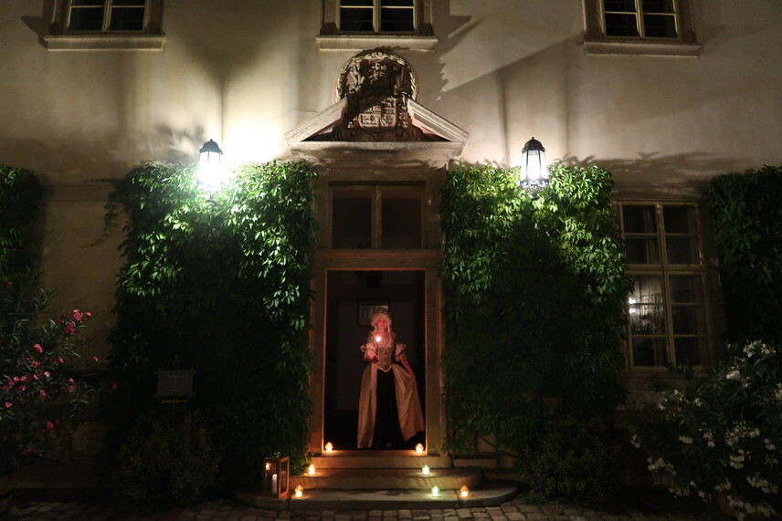 Žena v rokokových šatech se svící v ruce